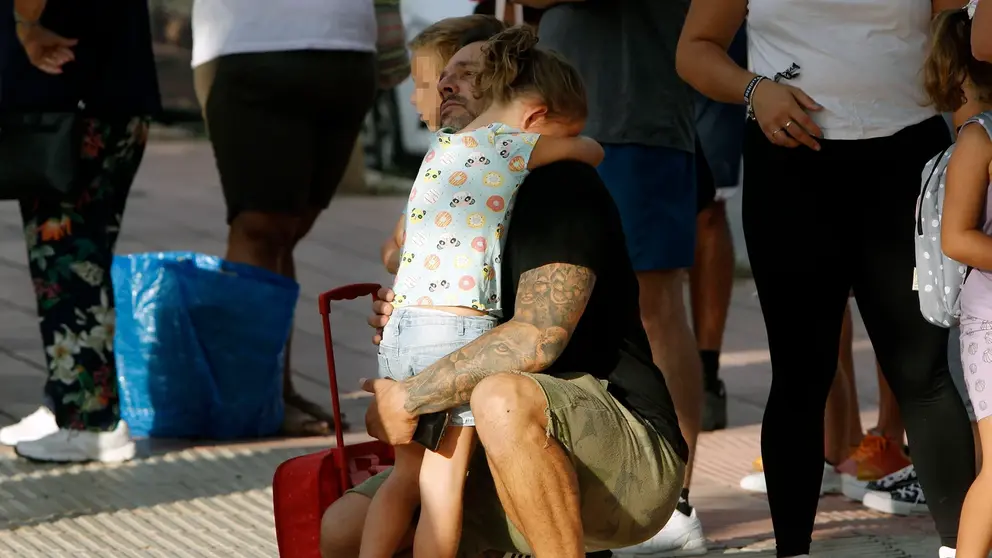 Ni&ntilde;a abrazando a su padre el dia de la vuelta al cole despu&eacute;s de las vacaciones de verano.