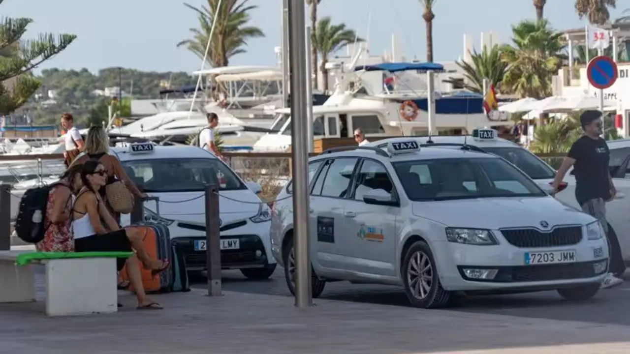 Turistas esperando en una parada de taxi en Baleares.